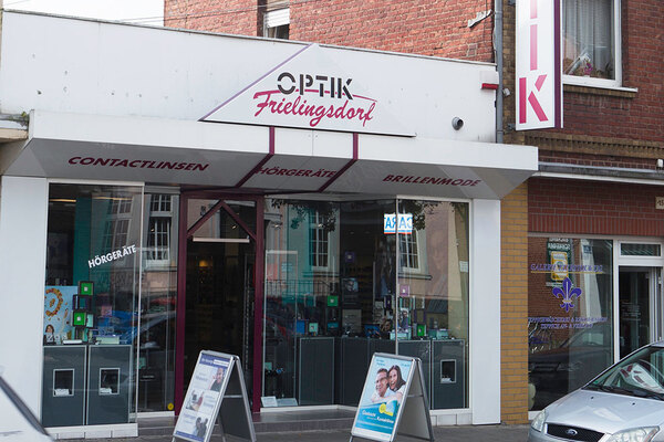 Fassade eines Optikergeschäfts mit Angeboten für Brillen, Hörgeräte und Kontaktlinsen.
